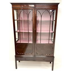 Early 20th century mahogany display cabinet, projecting cornice above two doors enclosing two lined shelves, two drawers, square supports 