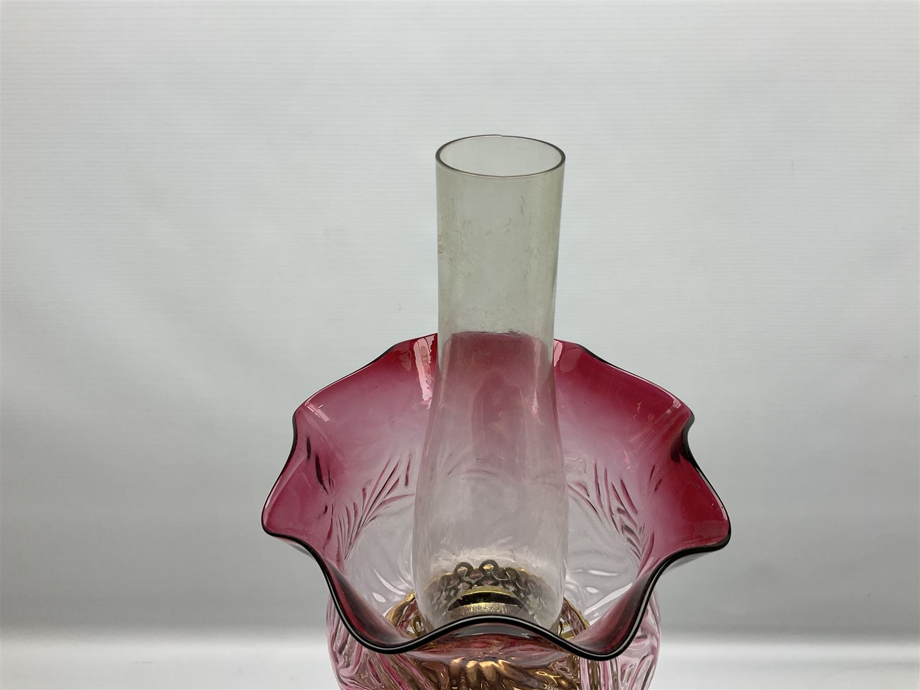 20th century Hawksworth, Eyre & Co silver plated oil lamp, the octagonal stepped base with engraved dedication, leading to an octagonal column supporting a faceted clear glass reservoir, Hinks Duplex burner, clear glass chimney, and cranberry glass shade, overall H71.5cm