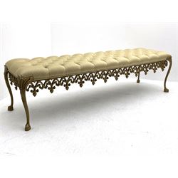 Gilt cast metal window seat bench, rectangular cushioned seat upholstered in buttoned pale gold fabric, ornate foliate cast base on cabriole supports