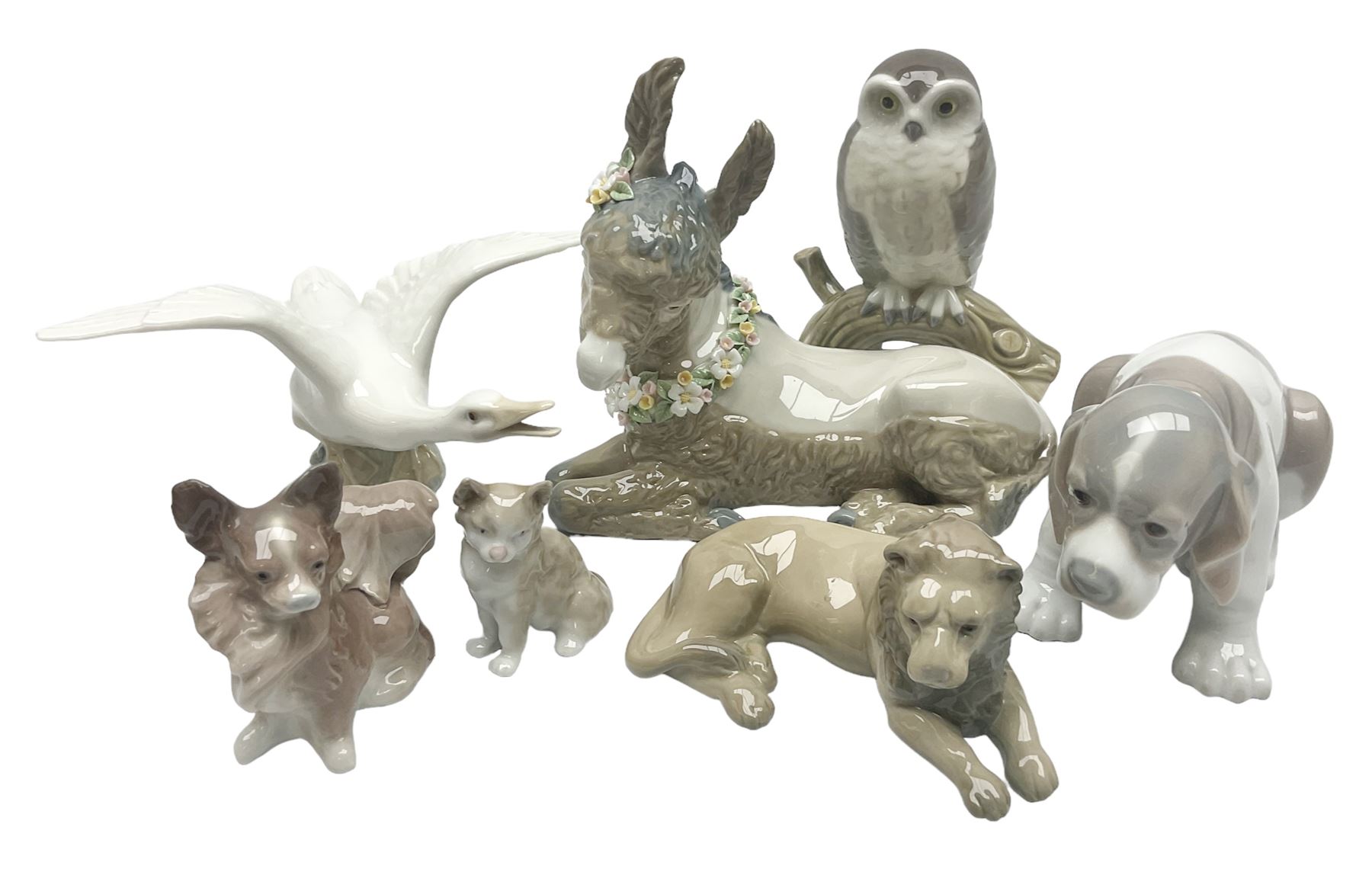 Lladro figures of animals, comprising Mini Lion no 5436, Beautiful Burro no 5683, Hawk Owl no 5422, Beagle Puppy Sitting no 1071, Duck Flying no 1264, Miniature Cat no 5308 and Small Papillon Dog no 4749, four with original boxes, largest example H14cm