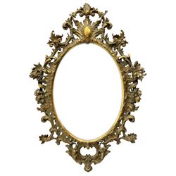 Large 19th century Florentine style oval mirror in carved giltwood and gesso frame, cartouche pediment over shell surround, decorated with foliate c-scrolls and flower heads