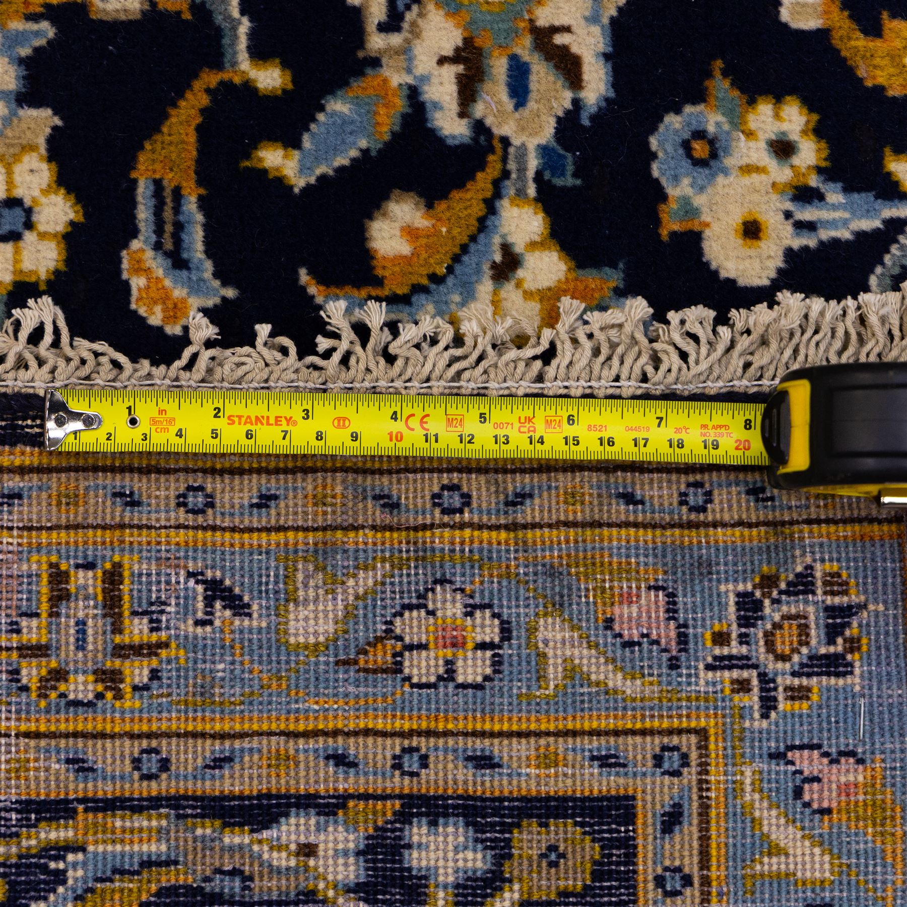 Central Persian Kashan hand-knotted rug, deep indigo field with central floral medallion surrounded by an all-over arrangement of palmettes, flowering vines, and tendrils with matching spandrels enclosed by a pale blue floral main border with multiple narrow guard stripes, with cotton fringe ends 