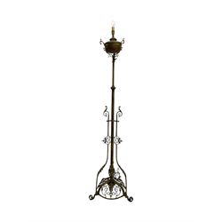 Victorian brass converted oil lamp stand, telescopic stem with scrolled uprights terminating to scrolled feet, dished base decorated with scrolling cast metal work and grotesque masks 