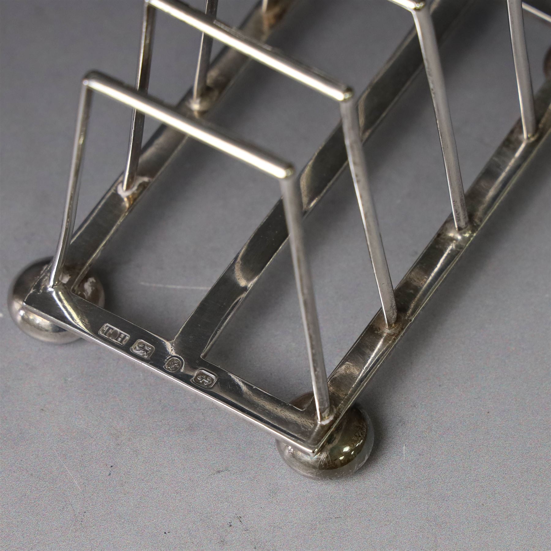 Victorian silver toast rack, with five angular bars and loop handle, upon four squat bun feet, hallmarked Thomas Hayes, Birmingham 1893, height including handle H10cm