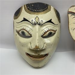 Three carved wooden Balinese topeng masks, one depicting Rangda and two others 