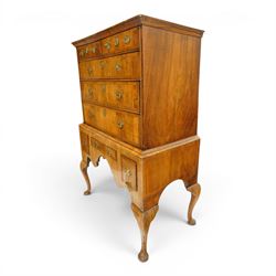 George II figured walnut chest-on-stand, the moulded cavetto top over two short and three long graduating cross-banded drawers, each fitted with pressed brass handle plates, the base fitted with three further drawers over a shaped apron, raised on cabriole supports with pad feet