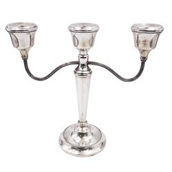 Modern silver mounted three branch candelabra, the tapering stem supporting a central candle holder and two curved branches with candle holders, upon weighted stepped circular foot, hallmarked A T Cannon Ltd, Birmingham 1973, H22.5cm