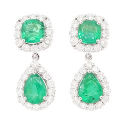 Pair of 18ct white gold emerald and diamond pendant earrings, each stud set with a cushion...
