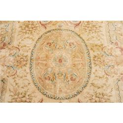 Large Aubusson design flatweave carpet, cream ground centred by oval medallion decorated with scrolling acanthus leaves and flowerheads, surrounded by floral sprays, foliate scrolls and rocaille motifs in muted pink, blue and gold tones, enclosed by conforming foliate border