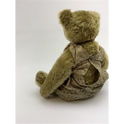 Early 20th century German Steiff teddy bear c1910 with wood wool filled humped back mohair body, swivel jointed head with black boot button eyes and horizontally stitched black nose and mouth, FF metal button to left ear, jointed elongated limbs with felt paw pads and black stitched claws H13