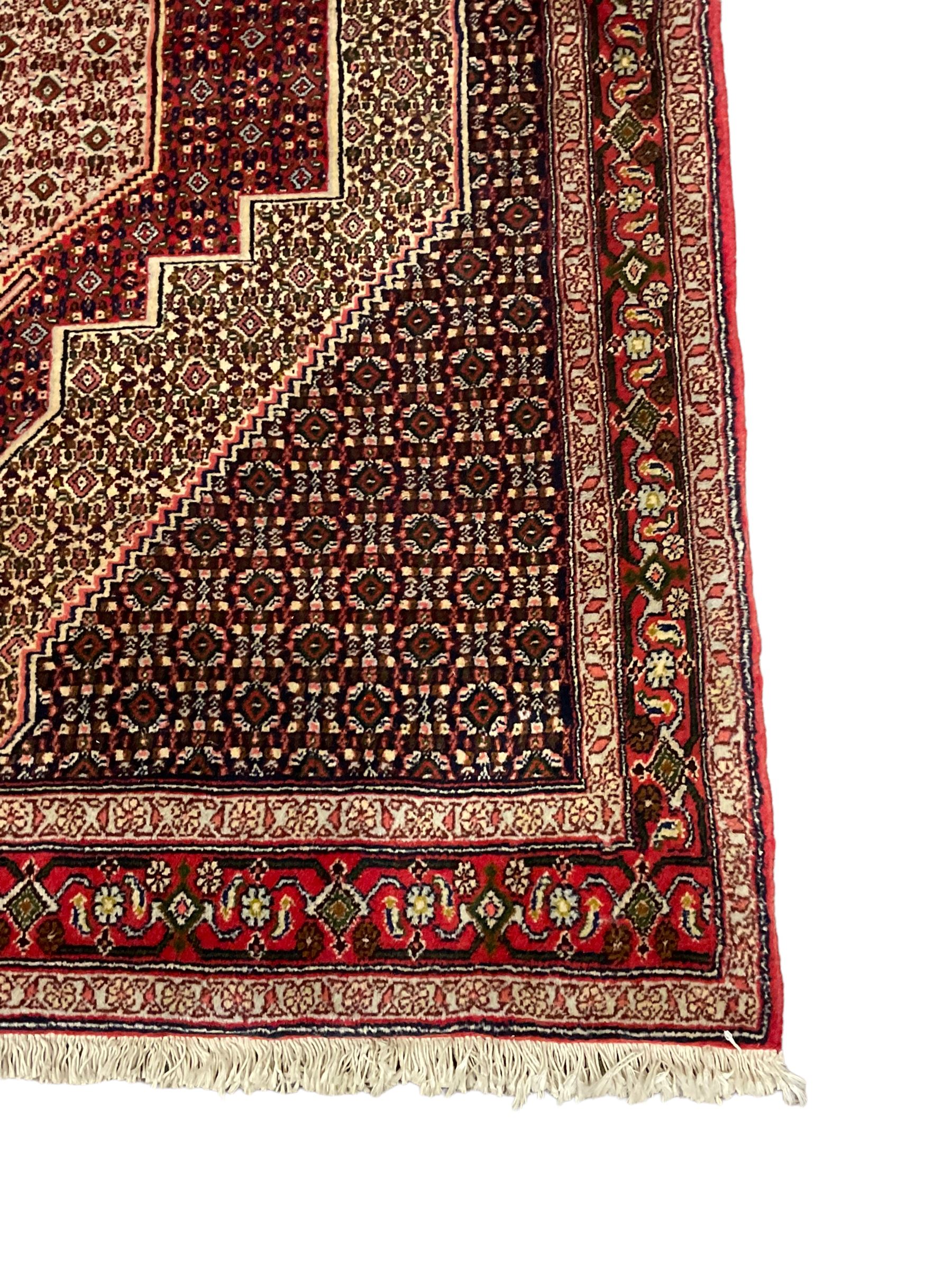 Persian Hamadan rug, lozenge field and decorated with repeating Herati motifs, the band border with repeating design decorated with stylised plant motifs