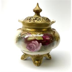 A small Royal Worcester potpourri jar and cover, shape 261, the bulbous body hand painted with pink roses, supporting a gilded and burnished pierced cover, upon four scroll feet, with puce printed mark beneath, H10.5cm.