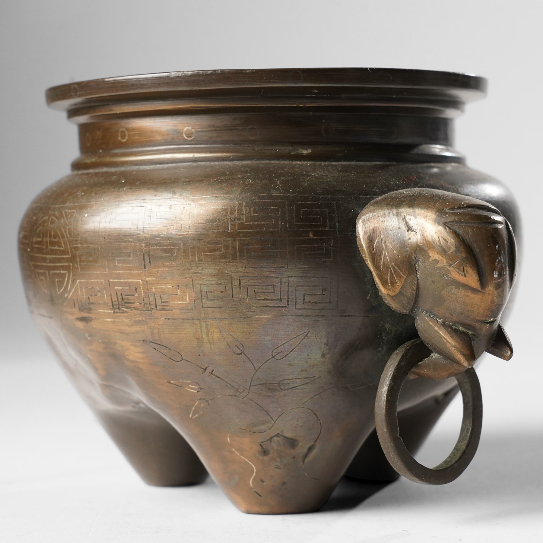 Chinese bronze tripod censer, of squat globular form, the body decorated with a band of Greek key motifs, the twin handles formed as two elephants heads, with incised shi shou two-character mark to base, H10cm