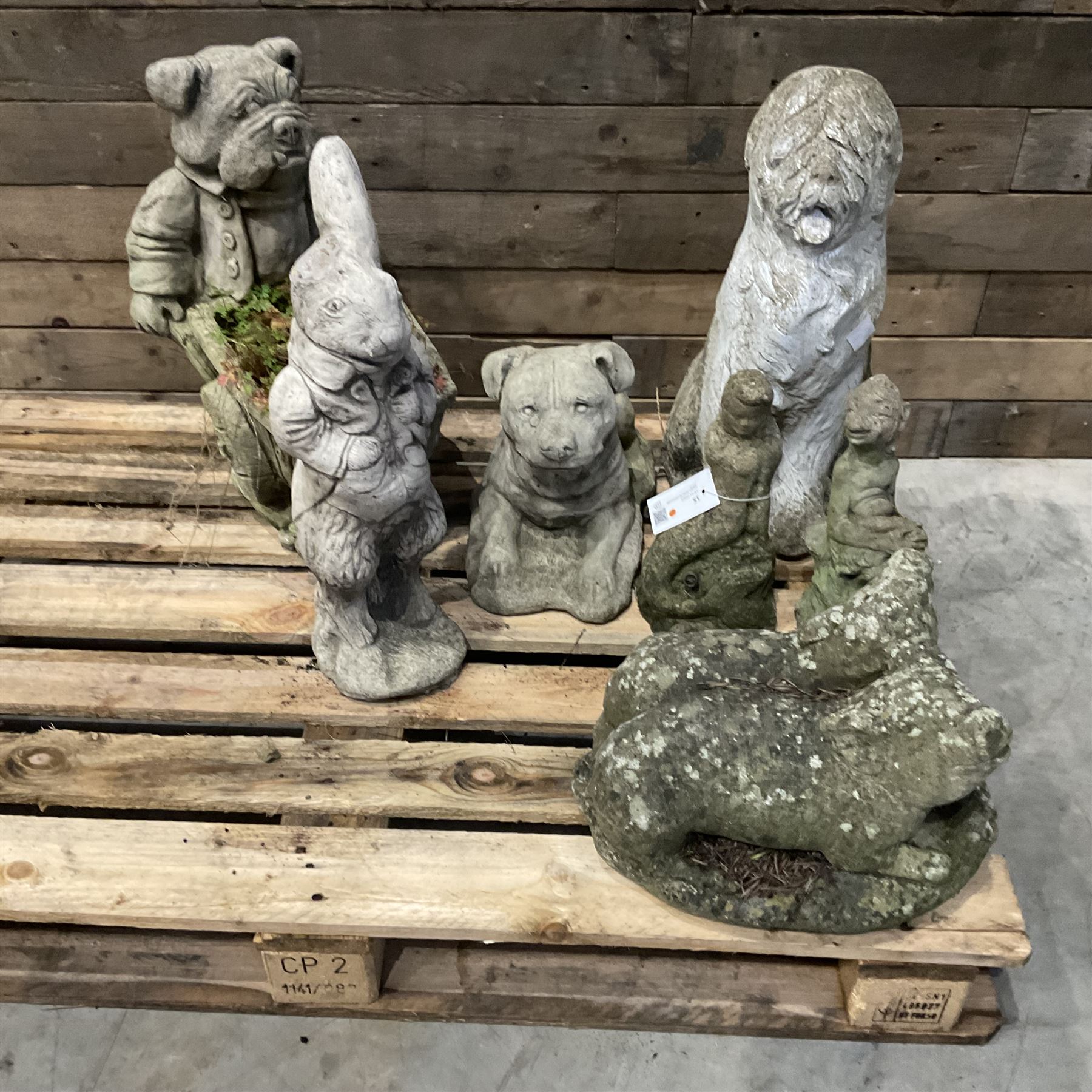 Various cast stone and composite garden ornaments, to include Peter Rabbit, goose, pigs, dogs, dog with wheelbarrow, painted metal bird bath and other, on two pallets