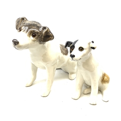 A Winstanley pottery figure modelled as a terrier dog, with inset glass eyes, marked beneath, H28cm, together with another similar smaller example, unmarked, H22cm.