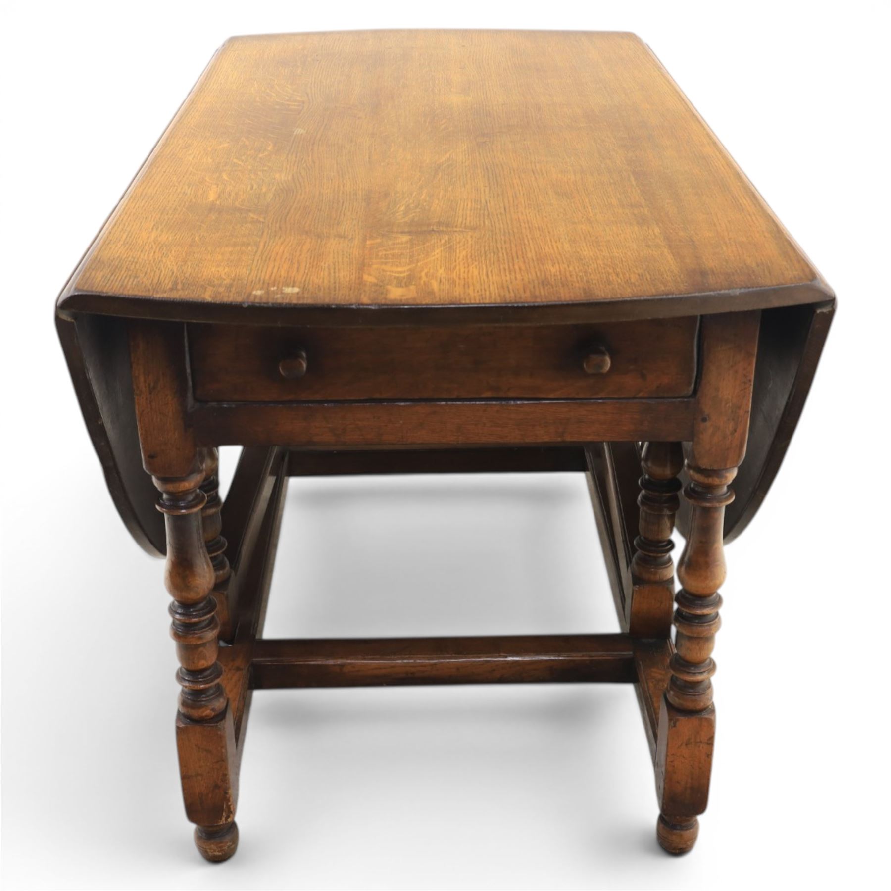 Titchmarsh & Goodwin - 18th century design oak oval drop-leaf dining table with leather dining chairs, the table with drop leaves forming an oval top extending to 180cm, with drawer to either side, raised on turned supports with gateleg, the chairs comprising two carvers in tan leather and two side chairs in green and tan leather backs, brass studded trim with turned uprights and stretchers