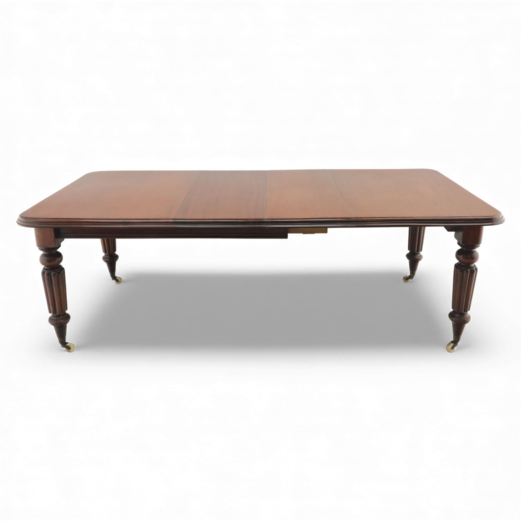 Large Victorian mahogany dining table, rectangular telescopic top with two additional leaves, upon turned knopped and reeded legs with ceramic casters, (Extends to 230cm)