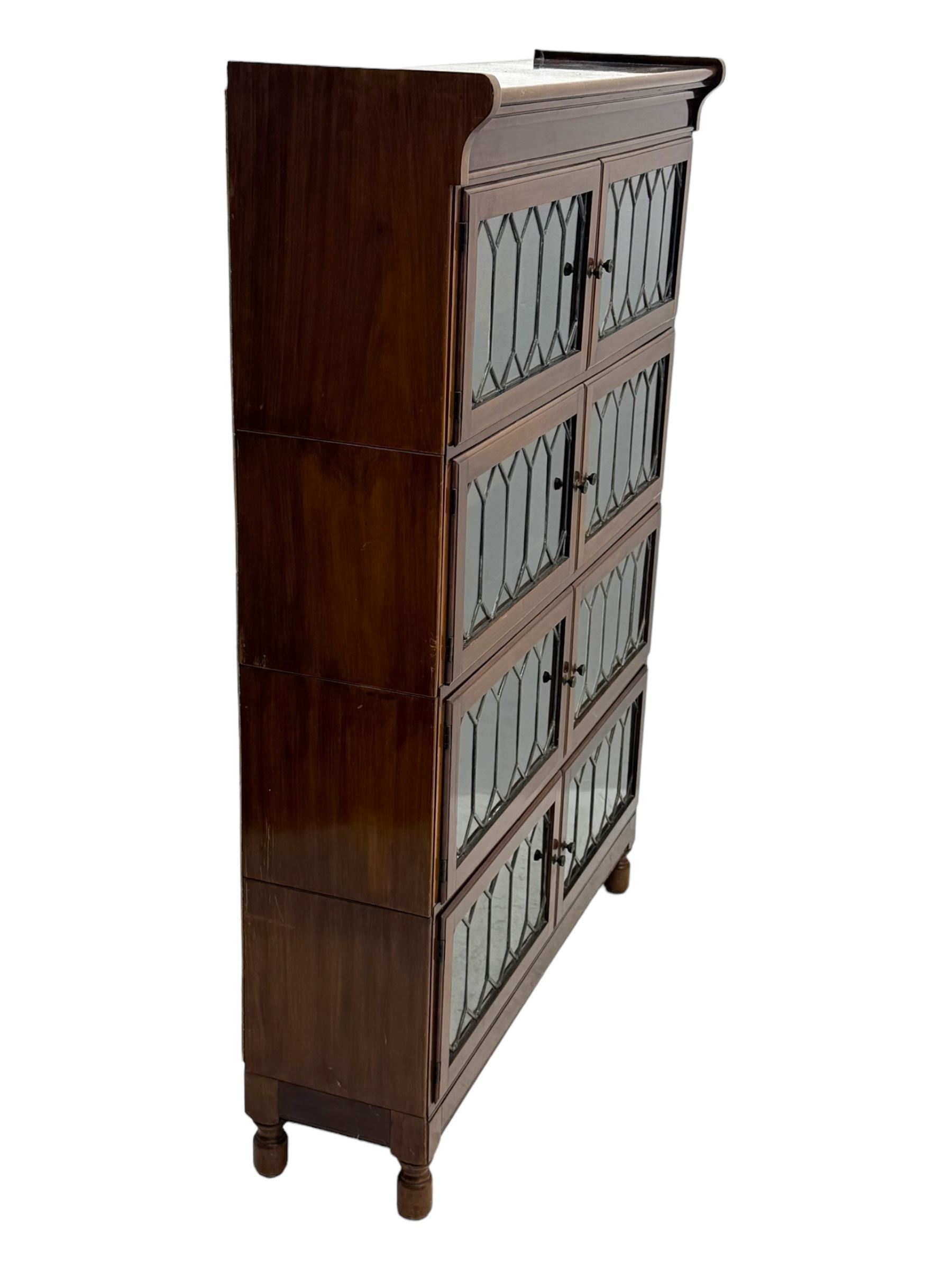 Early 20th century Globe Wernicke design stacking walnut bookcase, fitted with four sections each with two leaded glass doors, raised on turned feet