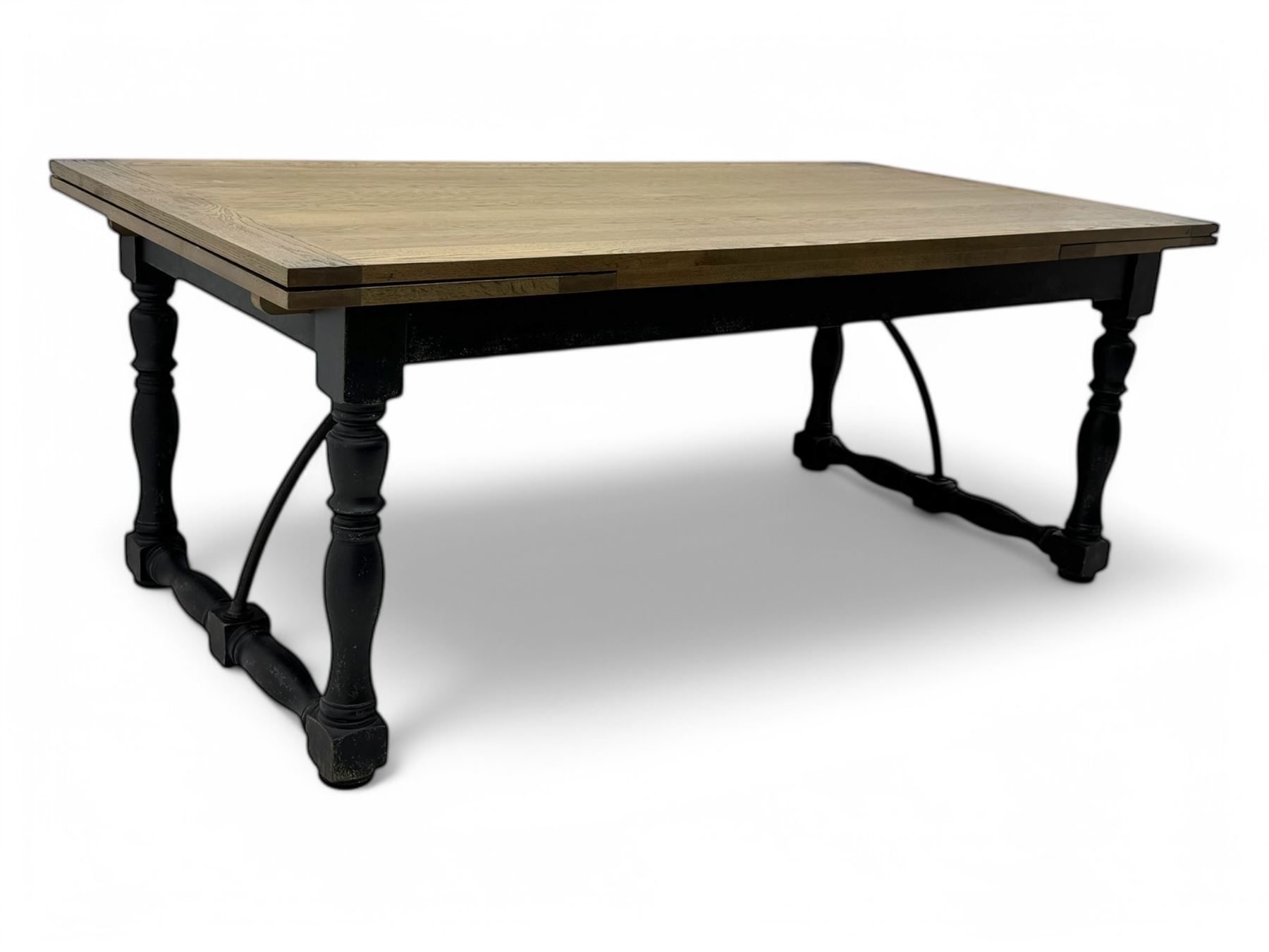 Barker & Stonehouse - large oak extending draw-leaf dining table, rectangular plank top over a black painted base, turned supports joined by shaped stretchers, extending at each end with pull-out leaves