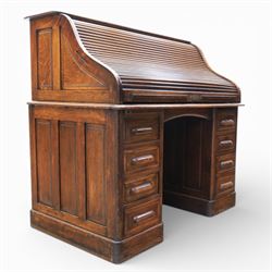 Globe Wernicke - Oak roll top desk, tambour roll top enclosing a fitted interior, raised on two pedestal bases with fitted drawers, raised on a plinth base 