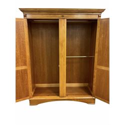 Large figured mahogany and cherry wood double wardrobe, the projecting cornice over figured panelled doors, fitted with hanging rails, skirted base