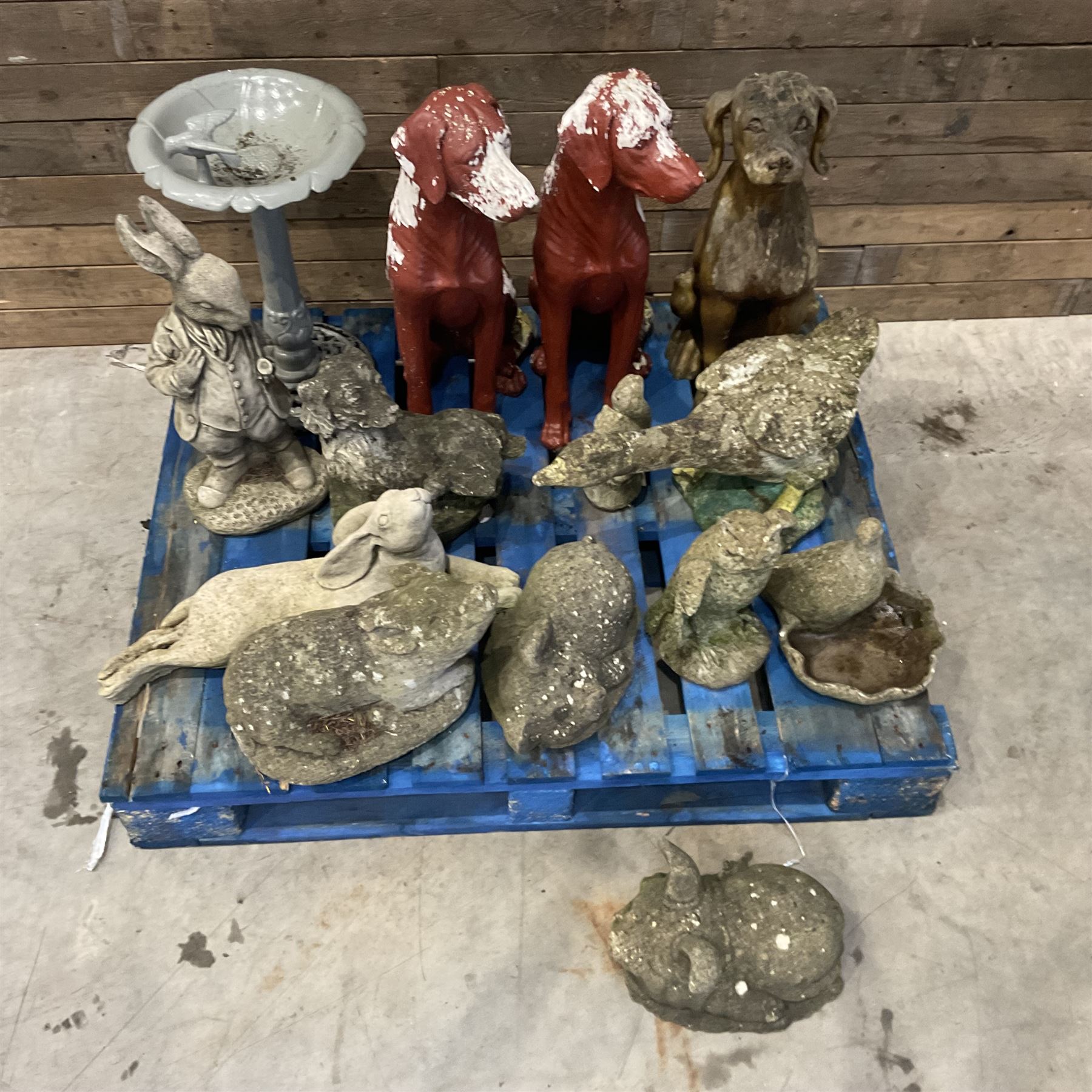 Various cast stone and composite garden ornaments, to include Peter Rabbit, goose, pigs, dogs, dog with wheelbarrow, painted metal bird bath and other, on two pallets