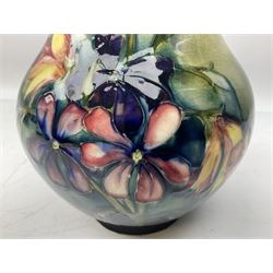 Moorcroft vase of baluster form decorated in the Spring Flowers pattern upon a merging green and blue ground, with impressed and painted marks beneath, H22.5cm