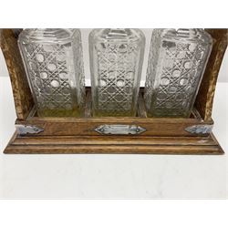 Silver plate mounted oak Tantalus, with three square glass decanters each with silver plate collars, one hallmarked silver decanter label, complete with key, H36cm