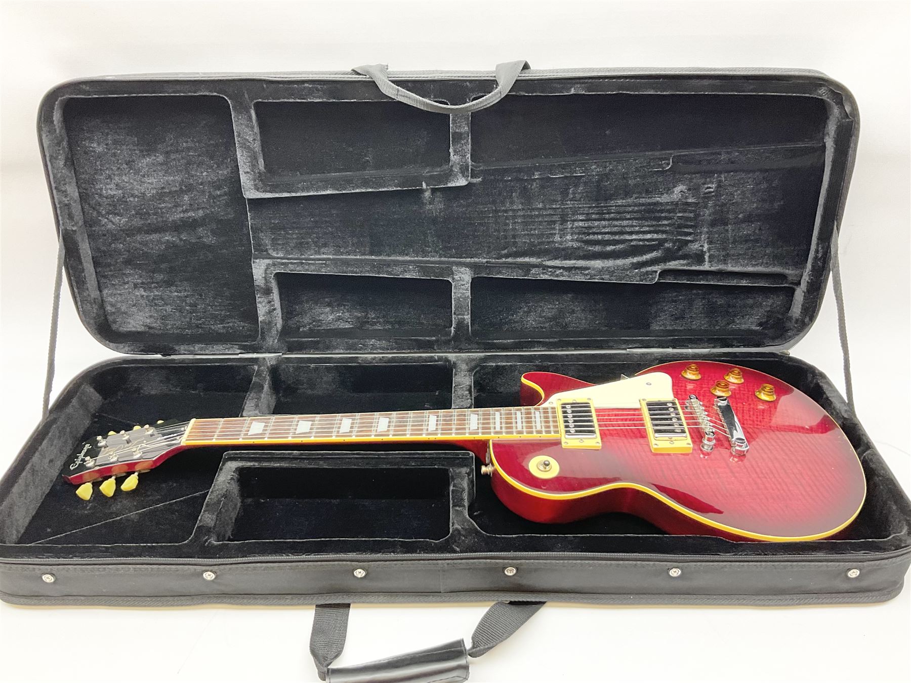 1980s Les Paul Epiphone limited edition cut-away electric guitar by Gibson, the burgundy coloured body with two pick-ups, volume and tone knobs and scratch plate, original tuning pegs, serial no.U6030215, 101cm overall; in modern Kinsman fitted carrying case
