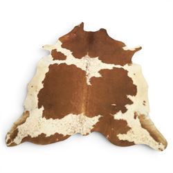 Cow hide rug or wall hanging, shaped with brown and white tones