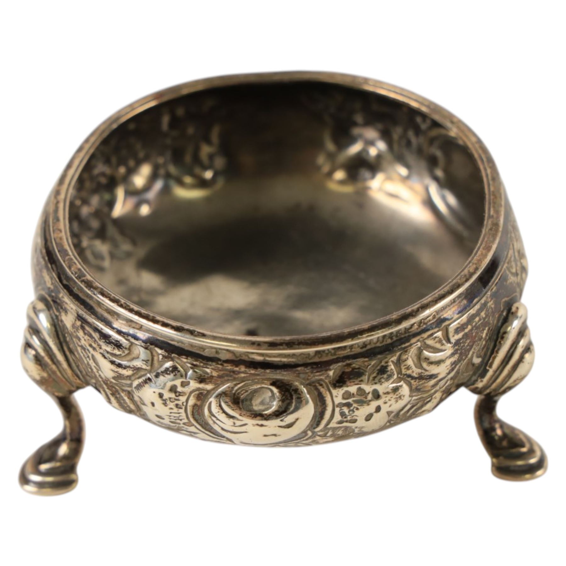George III silver open salt with embossed floral decoration and a pair of cut glass cruets with silver lids, all hallmarked