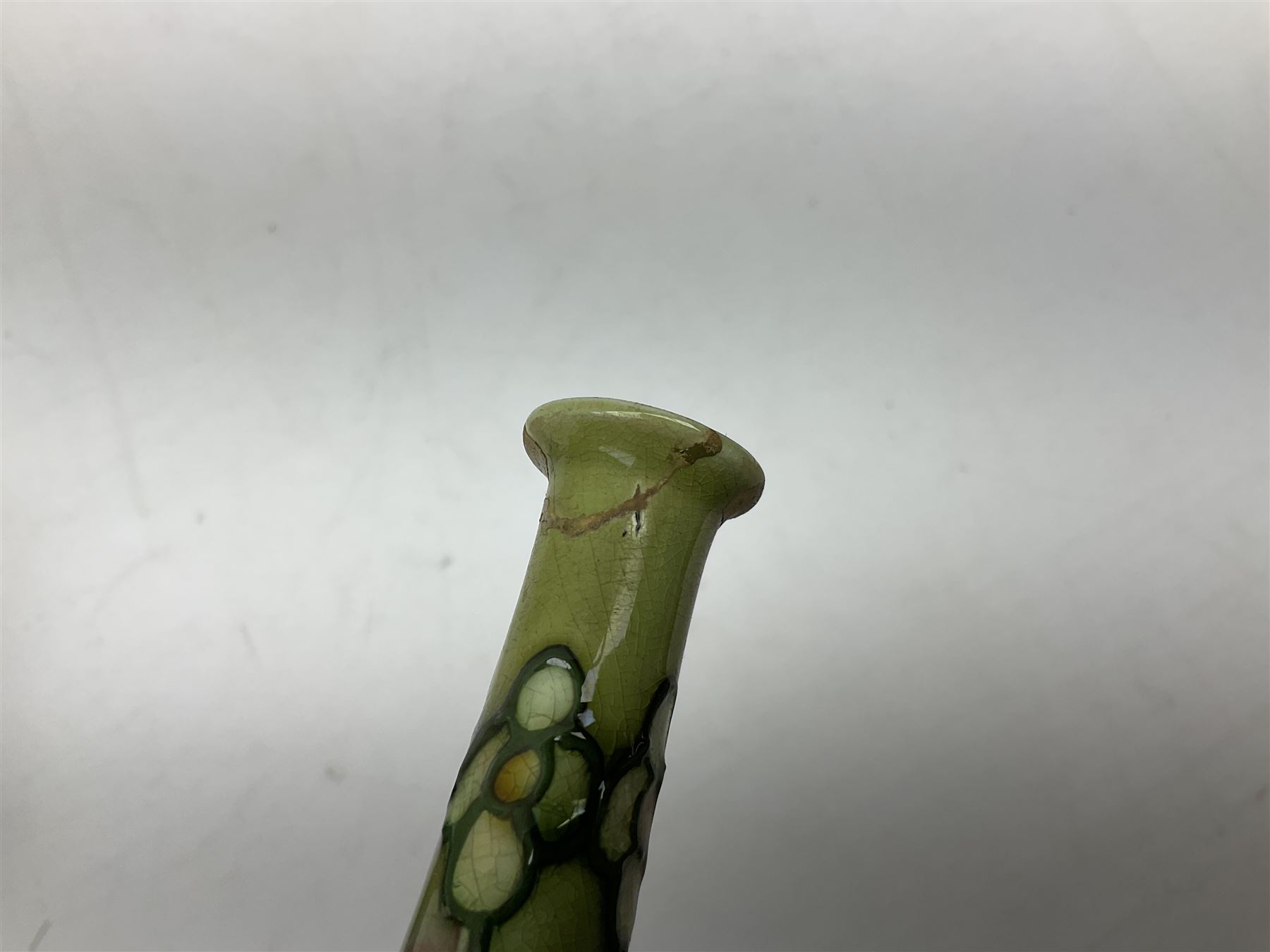 Three Minton Secessionist vases, with tube-lined stylised flower decoration, two upon a red ground and third upon a purple ground, all with printed mark to base 'Minton Ltd, No. 33', H13cm