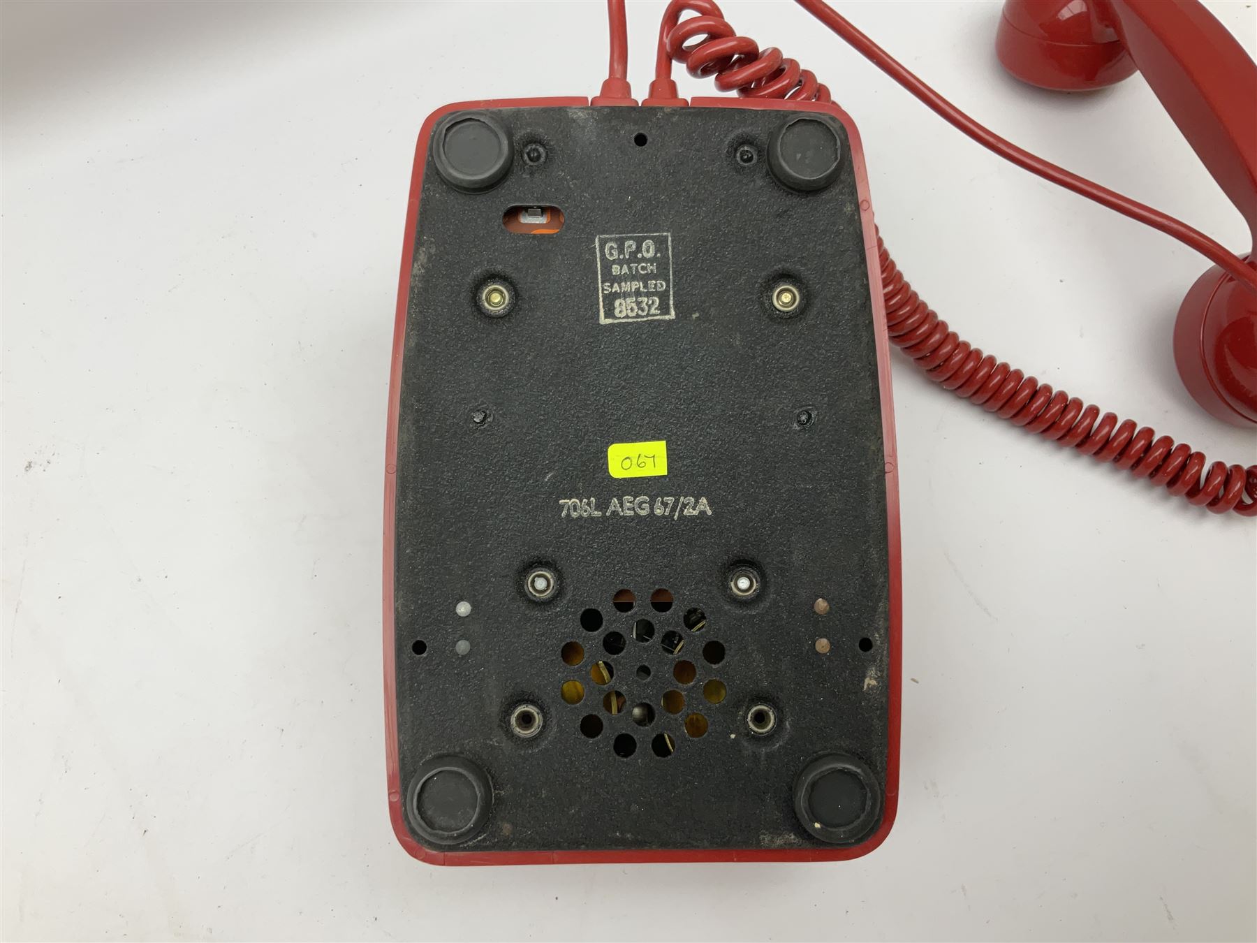 Two mid 19th century red telephones with rotary dials, comprising example marked G.P.O Batch Sampled 8532 706L AEG 67/2A, with junction box marked G.P.O, and another with chrome dial marked P.O Authorised Release 21034 746F EET 78/2