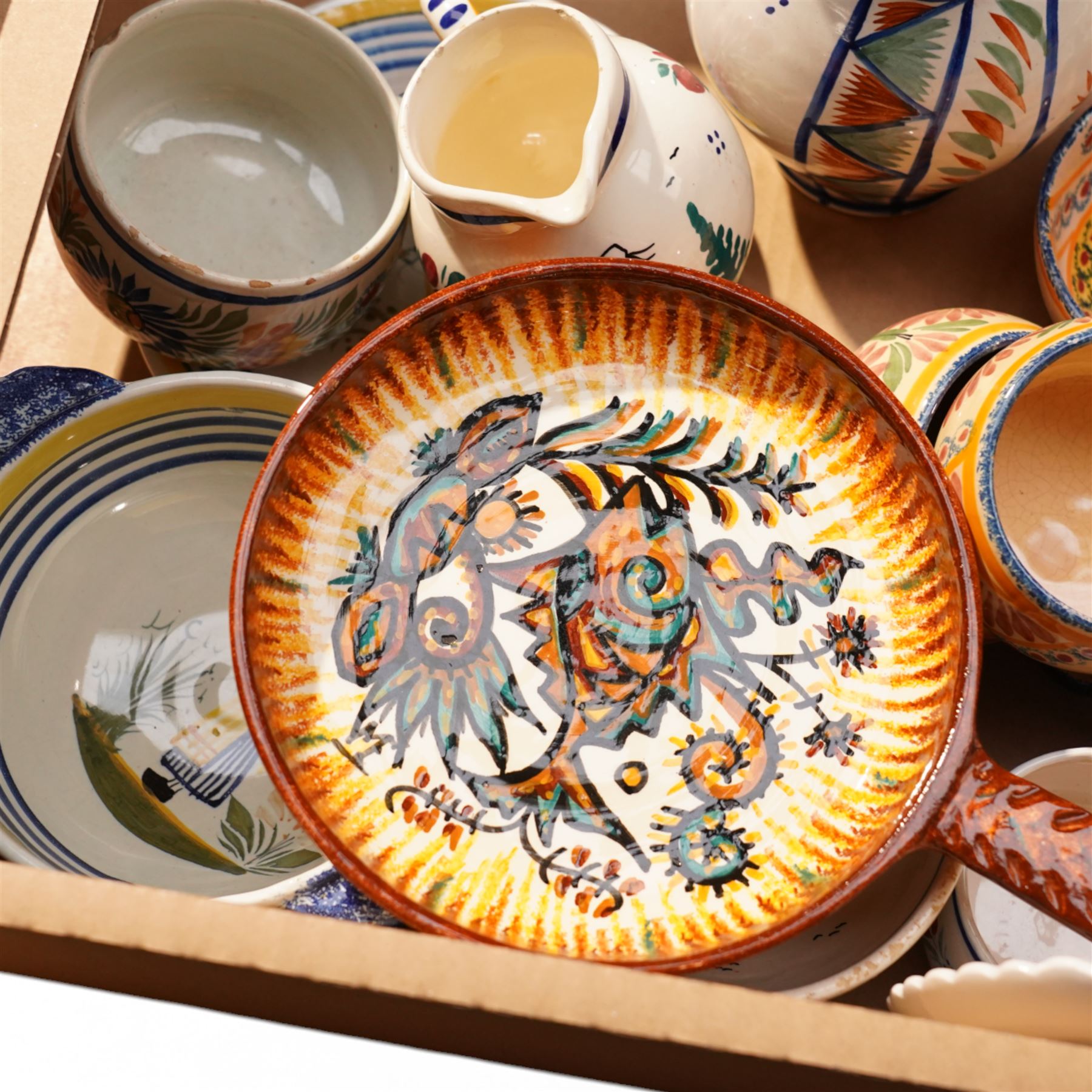 Collection of Quimper faience items including plates, cups, bowls and jug etc