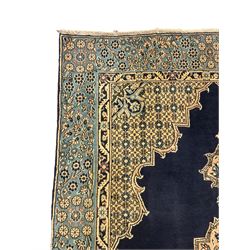 Central Persian Qum indigo ground rug with silk inlay, the plain field decorated with floral design medallion and lattice spandrels, the wide border decorated with trailing flowers and foliage 