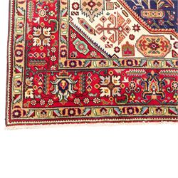 North West Persian carpet, the indigo field centred by a large terracotta and ivory medallion with matching pendants, decorated throughout with stylised palmettes, flowerheads and branching foliage, ivory geometric floral spandrels, enclosed by a red palmette border and narrow patterned guard bands