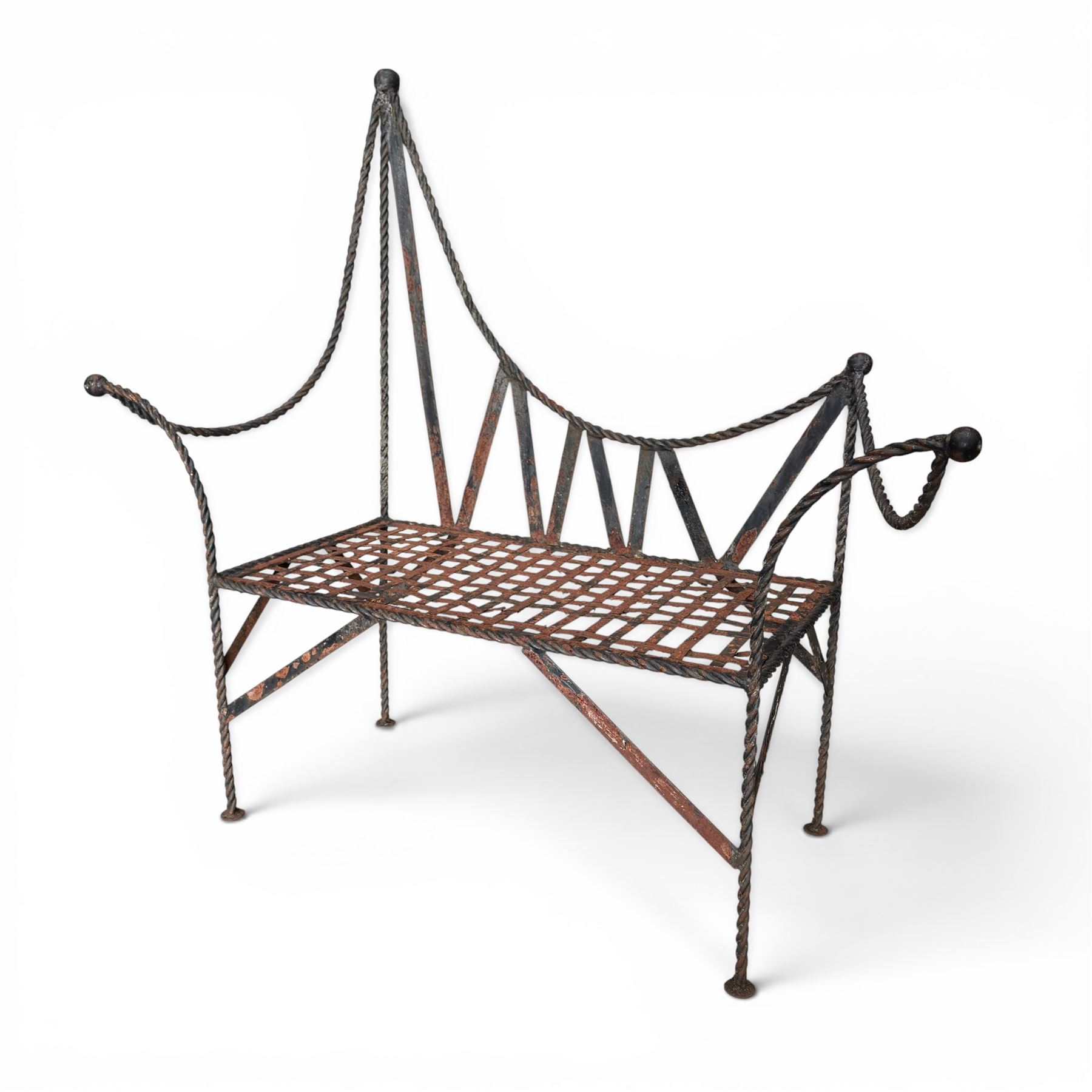 Victorian design wrought iron garden bench, with asymmetrical rope-twist frame, arched back and sides over out-swept arm terminals with ball finials, flanking a lattice seat, in antique black-painted weathered finish