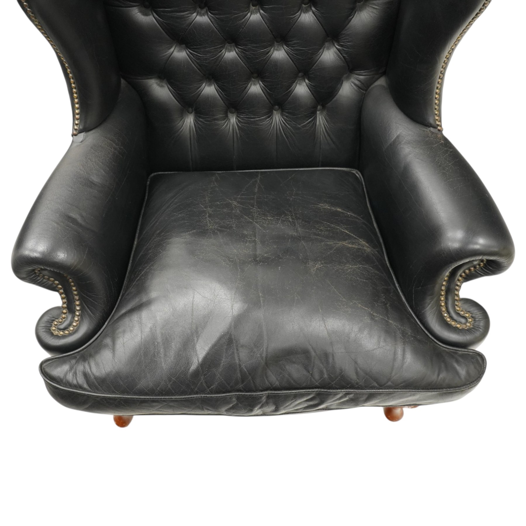 Pair of quality Georgian design wingback club armchairs, the high arched back with wings over rolled arms, upholstered in back-buttoned black leather with loose seat cushion, raised on foliate carved cabriole supports