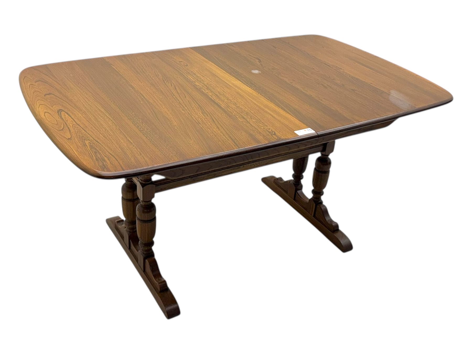 Ercol - late 20th century oak refectory dining table, rectangular top with rounded corners and central extending leaf, raised on turned baluster supports united by a stretcher (Extended 200cm)