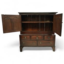 18th century oak dwarf press cupboard, the upper section with twin arched panel doors above three short and two long drawers, each with brass plate handles, shaped apron and stile feet, of compact country form