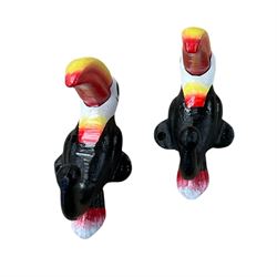 Three cast iron Guinness toucans in flight, together with two cast iron hooks