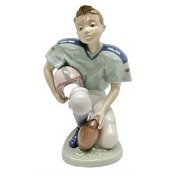 Lladro figure, Football Player, modelled as a young boy playing American football in kneeling position, sculpted by Joan Coderch, with original box, no 6107, year issued 1994, year retired 1998, H18cm