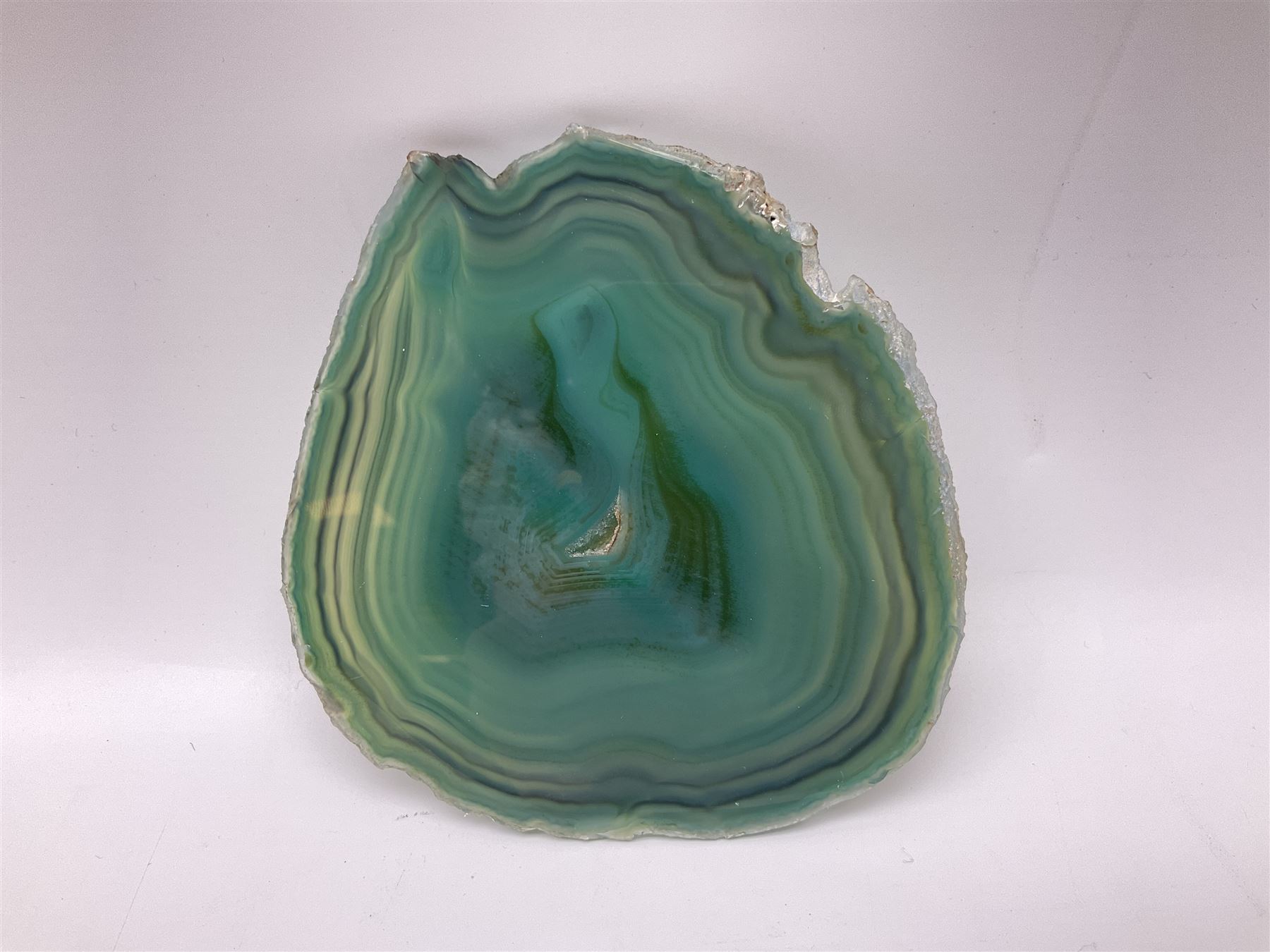 Pair of green agate slices, polished with rough edges, raised upon silvered metal stands, H23cm