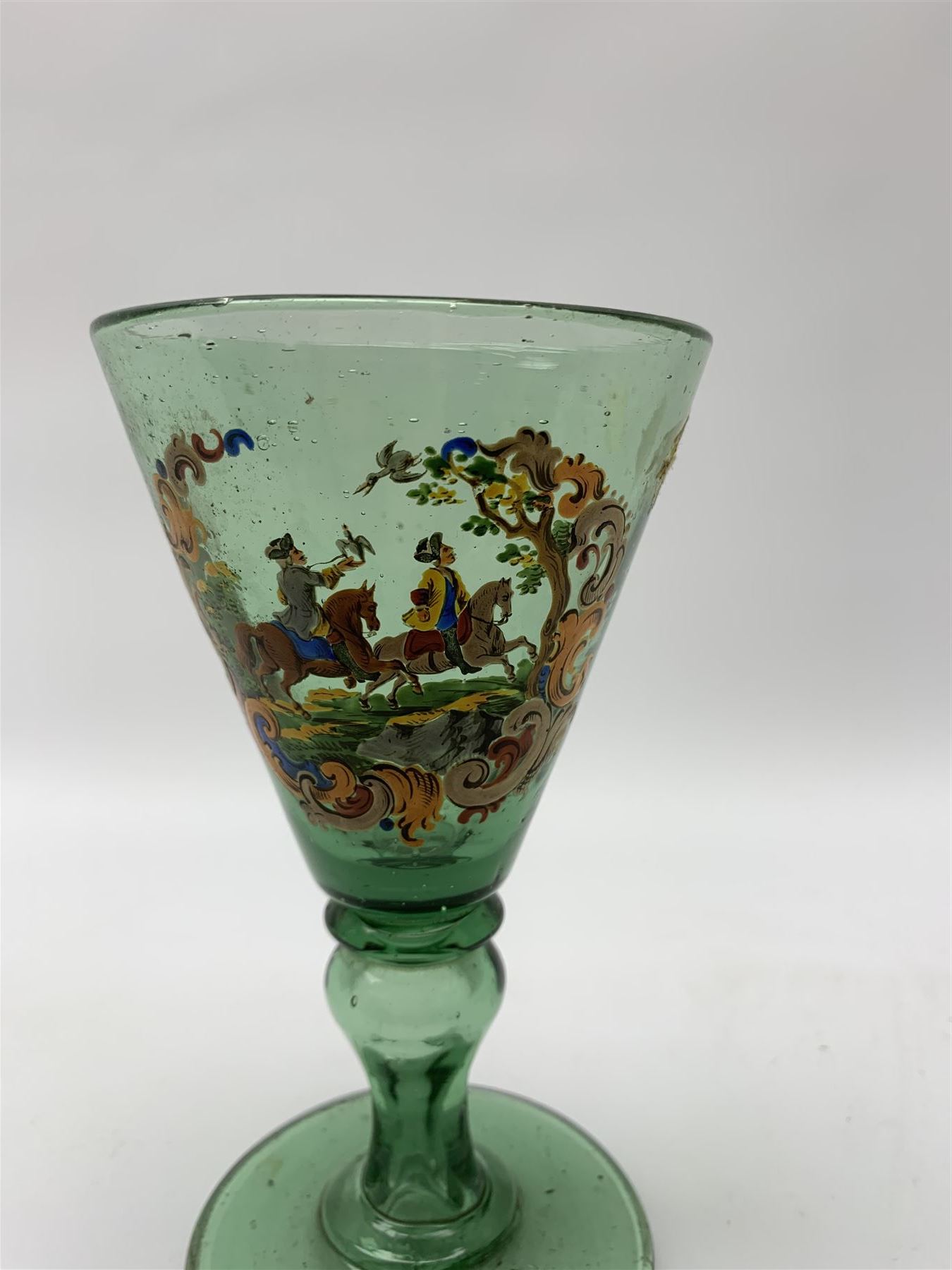 19th century bohemian green glass wine glass, the funnel bowl decorated in enamells with a Historismus hunting scene in the manner of Egermann & Lobmeyr, upon a baluster stem and circular foot, H14.5cm