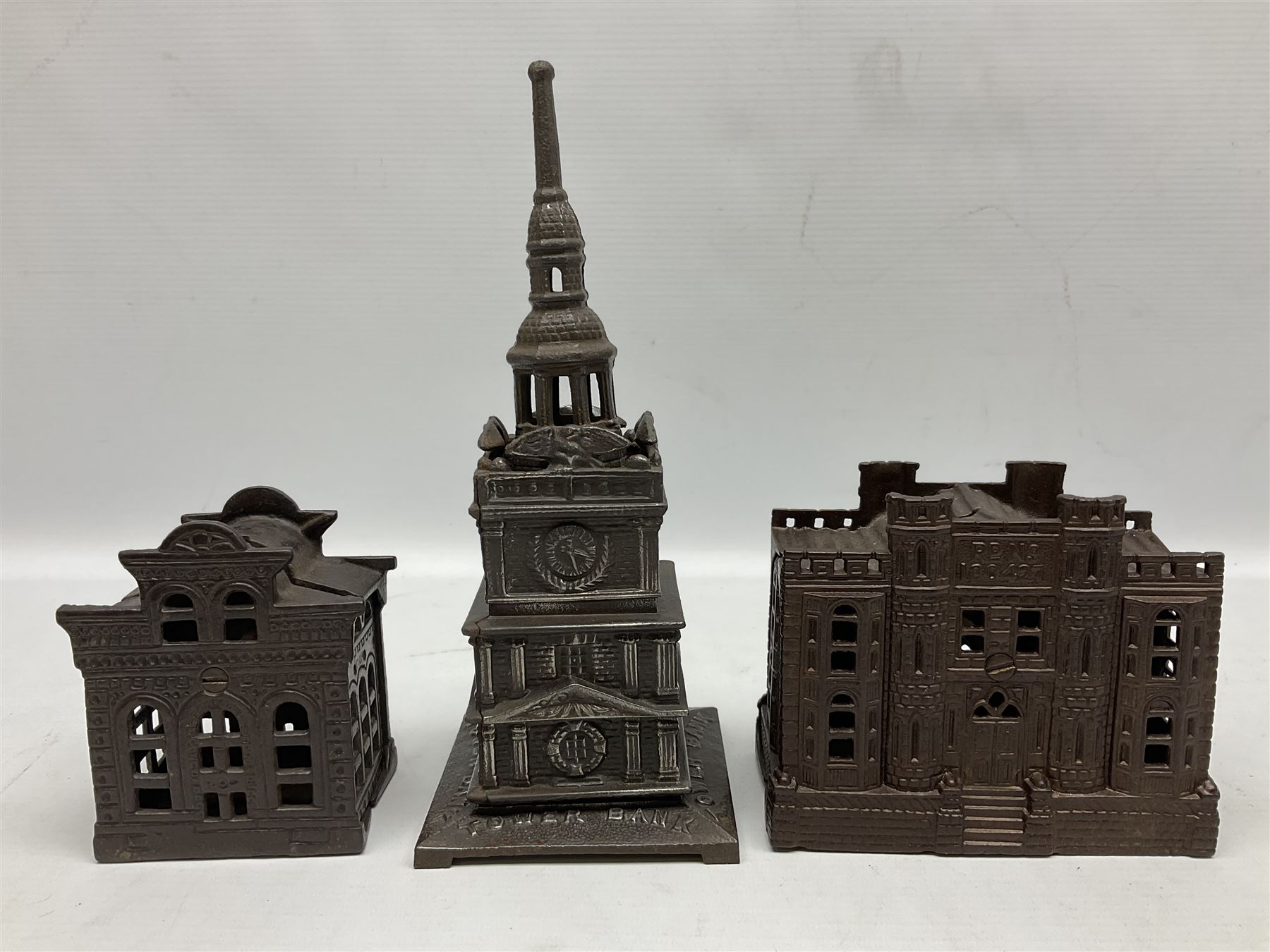 Five early 20th century cast-iron money banks as buildings - 'City Bank' c1904 H10cm; 'County Bank' c1905 H11cm; 'Town Hall Bank' c1900 H8.5cm; 'Tower Bank' c1902 H23.5cm; all made by John Harper; and 'Blackpool Tower Bank' c1907 by Chamberlain & Hill H18.5cm (5)