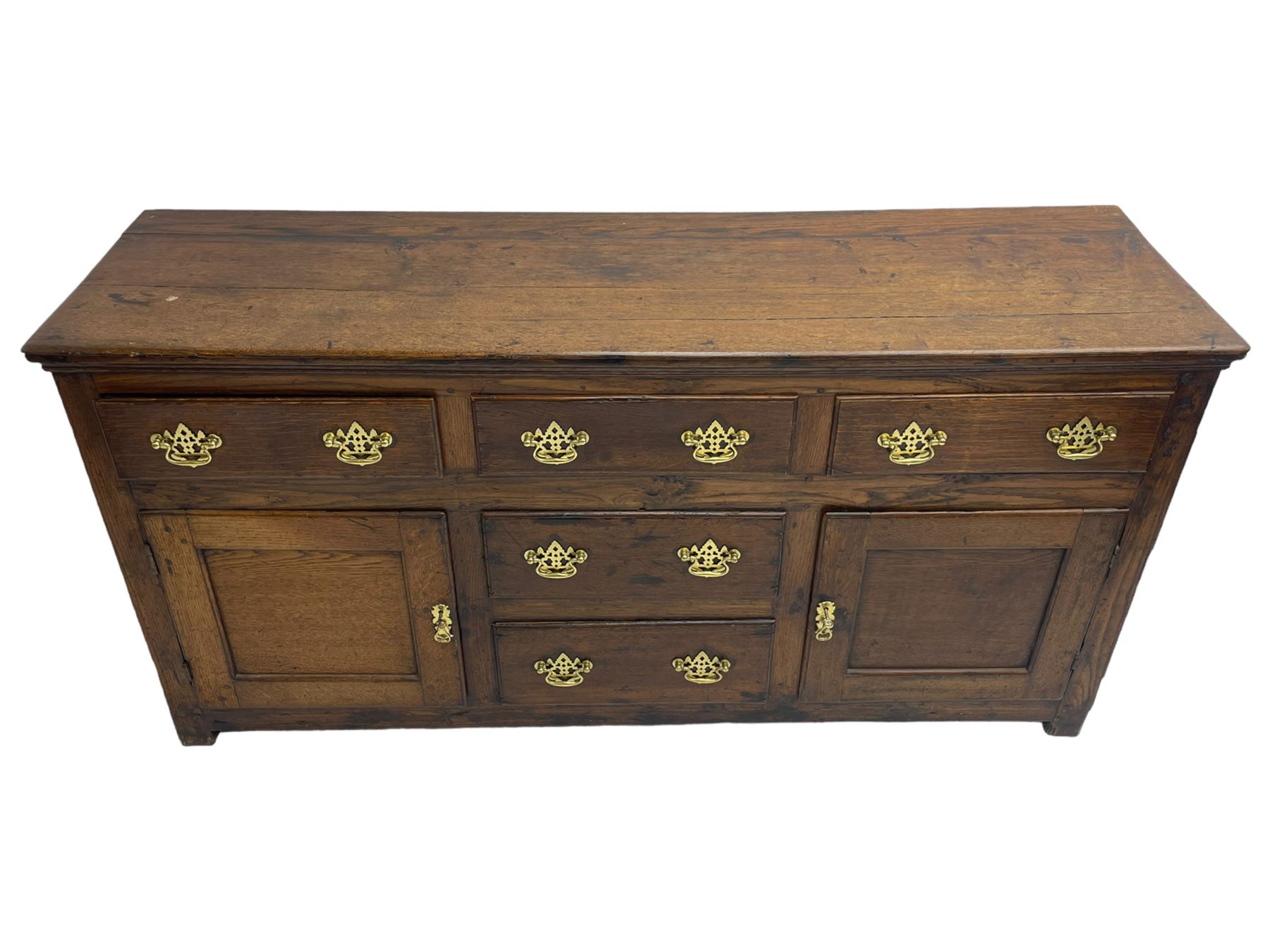 George III country oak dresser base,  rectangular top over with three central drawers flanked by two drawers and two panelled cupboards, each with moulded fronts, on stile feet
