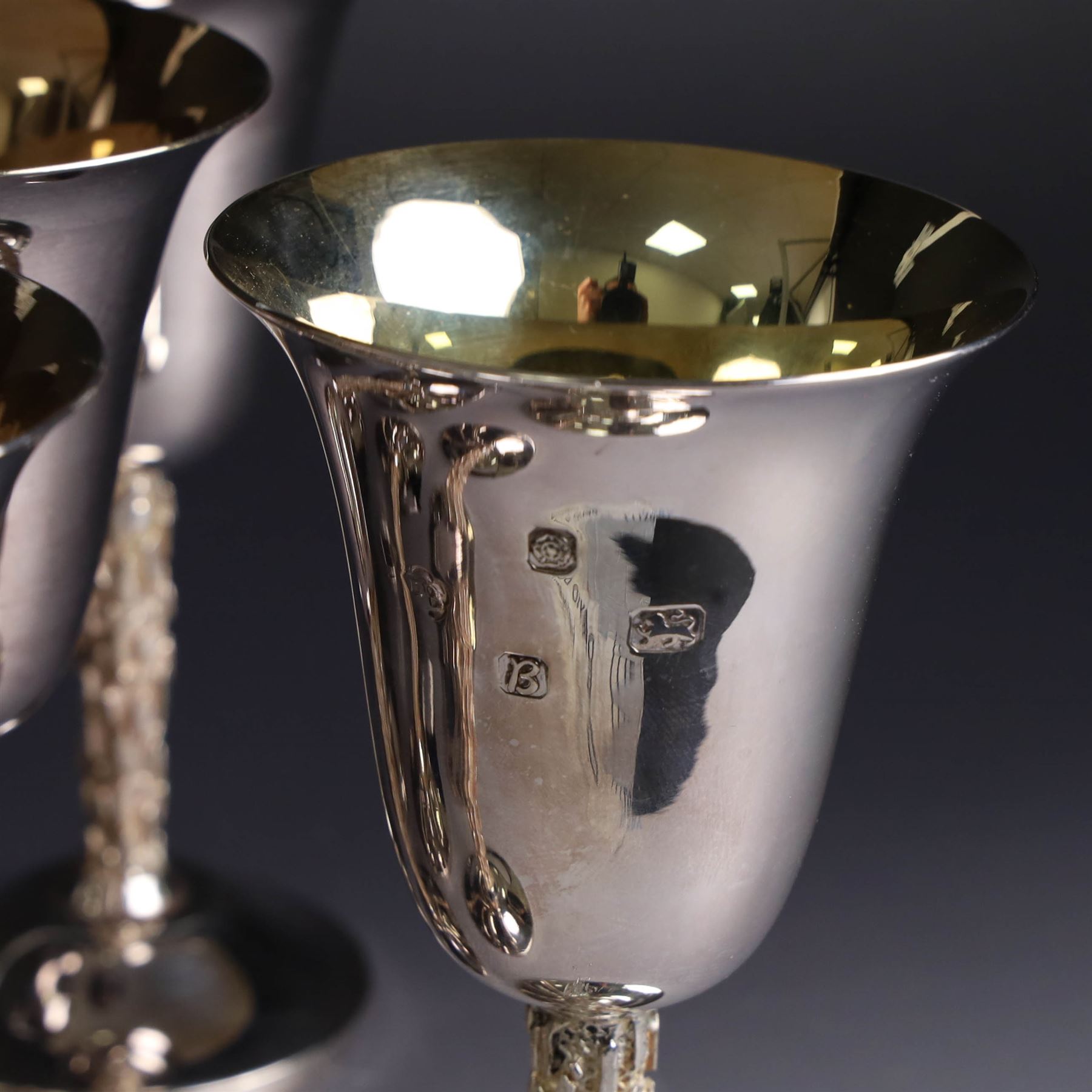 Eight silver goblets, comprising set of six, each plain fluted bowl with gilt interior, upon bark effect stem and domed circular foot, and a pair of very similar examples boxed with large hallmarks to bowls, hallmarked Pinder Brothers, Sheffield 1970 and Sheffield 1976, H14cm