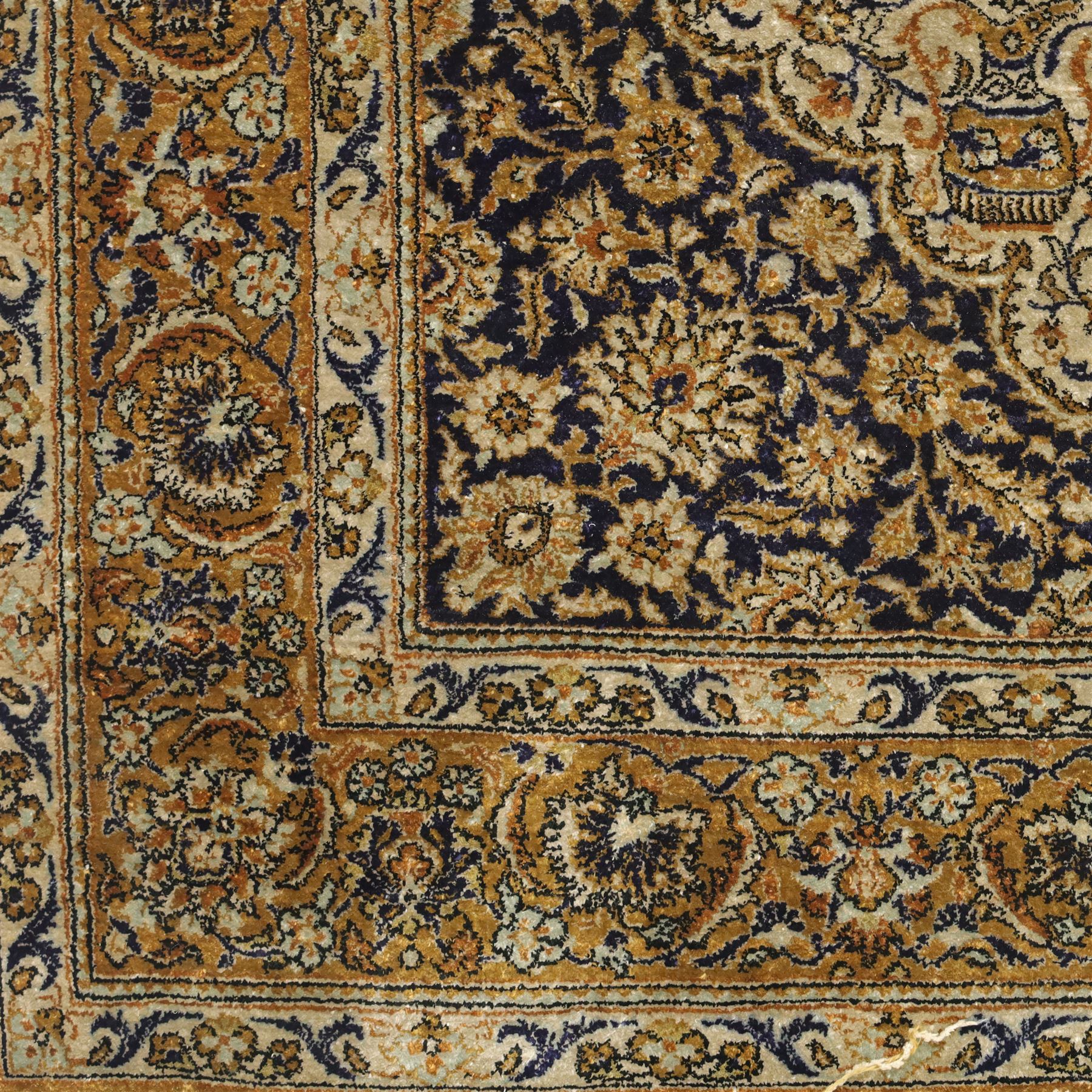 Persian Kashan design silk and wool blended rug, with a central medallion incorporating vases and scrolling floral motifs, set against a dark blue and ivory ground within a patterned border, some fraying to end fringes