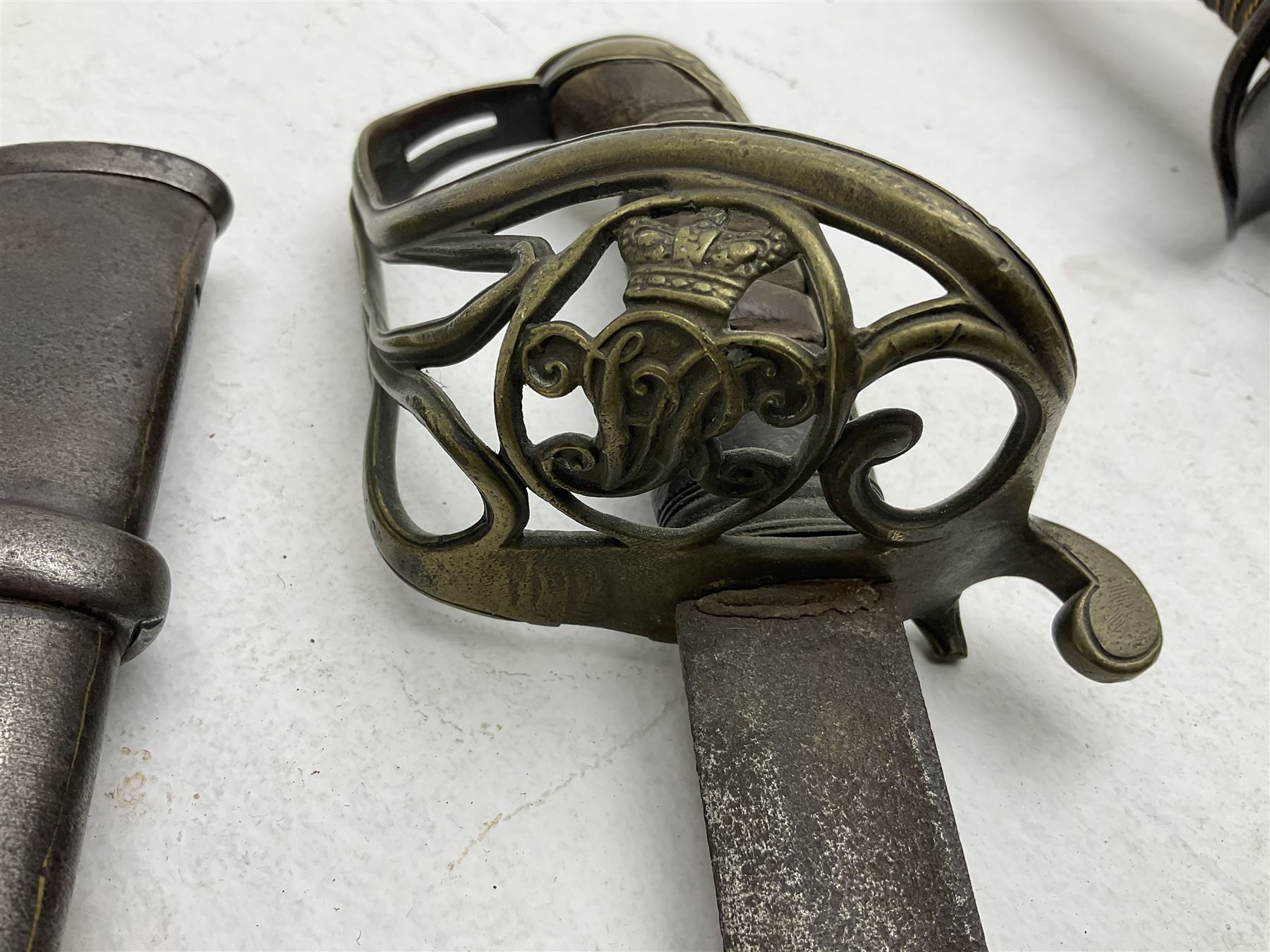 19th century Imperial German army heavy cavalry officers sword by Schnitzler and Kirschbaum, with 89cm single fullered steel blade and sheet steel basket hilt with teardrop cut-out and wire-bound leather grip L107.5cm overall; in steel scabbard with two suspension rings; and British Army 1822 Pattern Infantry Officer's sword in associated scabbard (2)