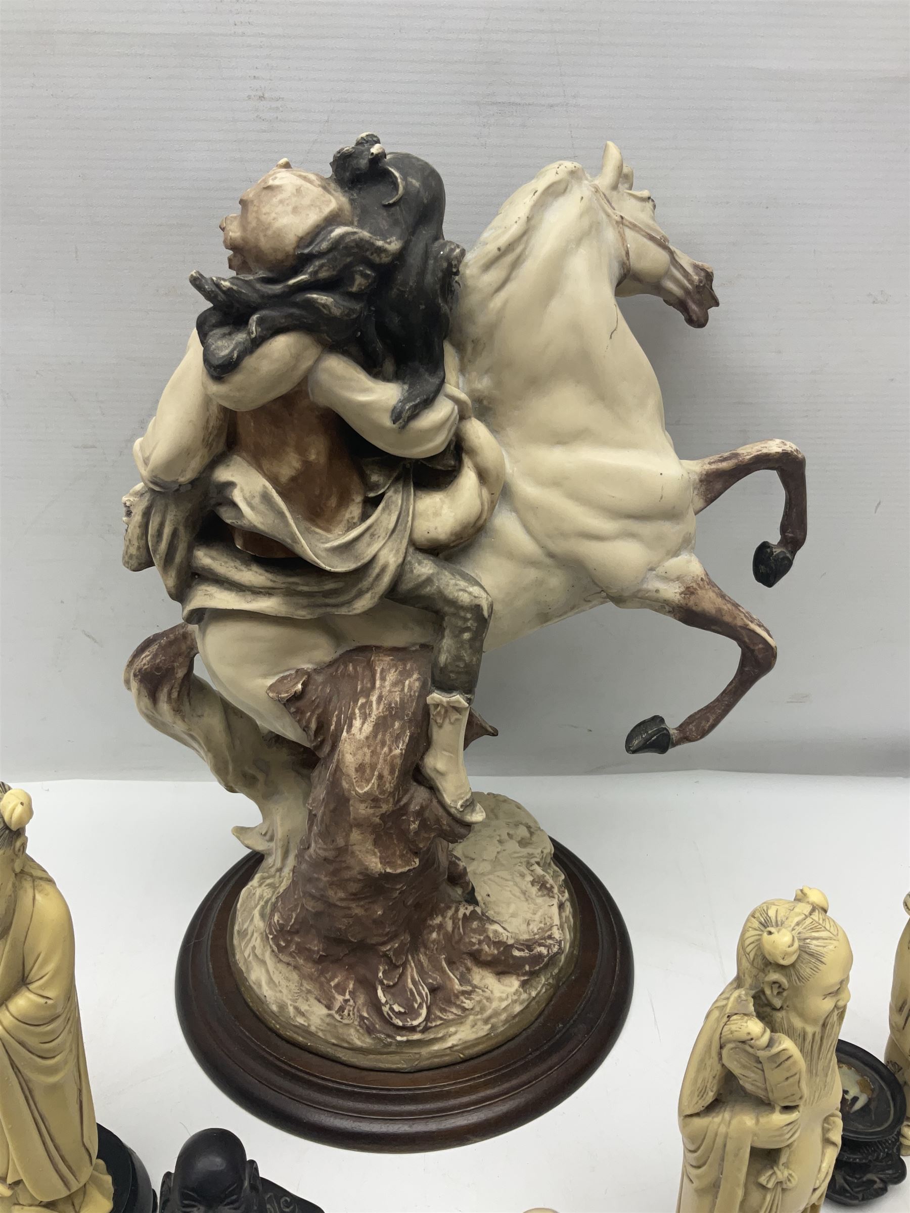 Composite figure of a couple upon a rearing horse, together with a collection of resin immortals and two bone chests 